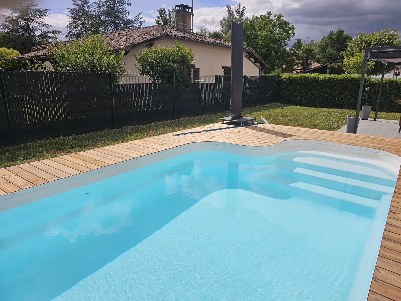 Piscine avec terrasse bois dans un jardin